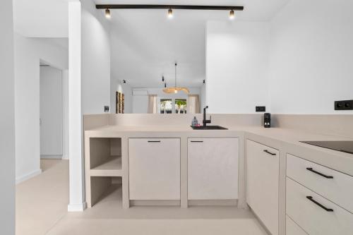 a white kitchen with white cabinets and a sink at Sorobon Bay Hotel in Kralendijk