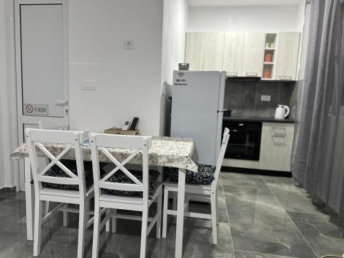 a kitchen with a table and chairs and a refrigerator at Apartman 2 in Šušanj
