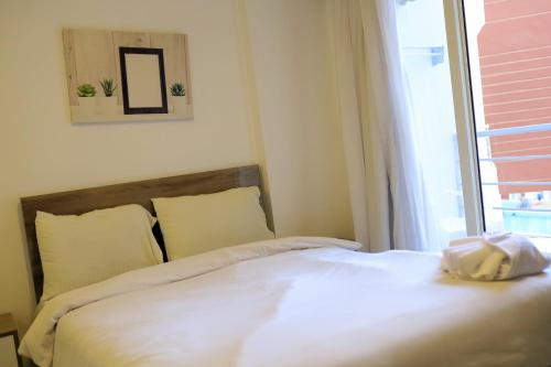 une chambre avec un lit blanc avec une fenêtre dans l'établissement One bedroom apartment in Aqua palm resort before Al Gouna, à Hurghada