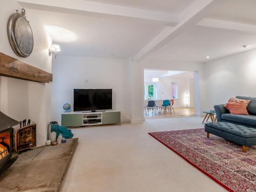 a living room with a tv and a couch and a fireplace at Tall Trees in Whitstable