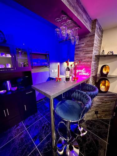 - un bar dans une pièce avec une table et des tabourets dans l'établissement SWEET DREAMS Love room & Spa, à Villeneuve-le-Roi