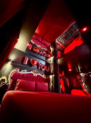- une chambre rouge dotée d'un lit avec des lumières rouges dans l'établissement SWEET DREAMS Love room & Spa, à Villeneuve-le-Roi