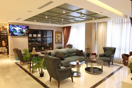 a living room with a couch and chairs and a tv at Londrina Hotel in Amman