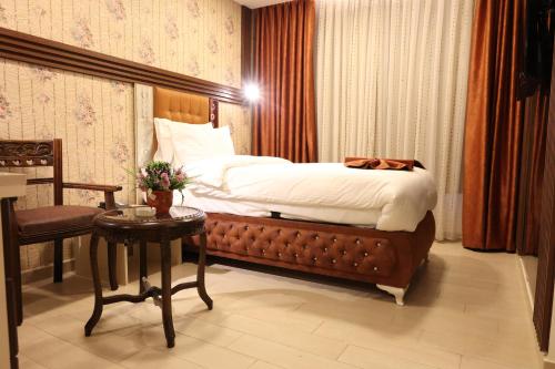 a bedroom with a bed and a table and a chair at Londrina Hotel in Amman