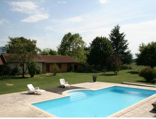 une piscine avec deux chaises et une maison dans l'établissement Gite Vercors-Chambaran, à Saint-Marcellin