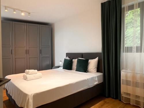 a bedroom with a bed with white sheets and green pillows at Helen & Friends 3 bedrooms in Balchik