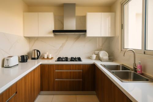 a kitchen with wooden cabinets and a sink at Elysium Signature Apartments Opposite Centaurus Mall Islamabad in Islamabad