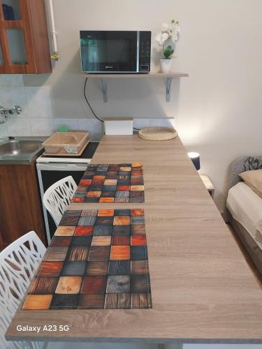 a long wooden table in a room with a kitchen at Repi-Tár apartman in Szolnok