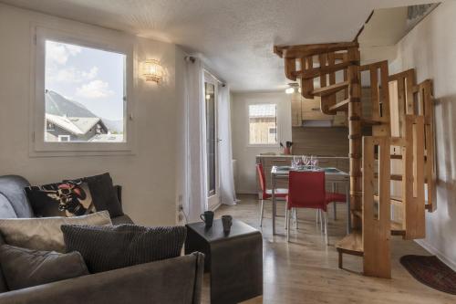 un salon avec un escalier en colimaçon et une table dans l'établissement Le Triolet - Centre-ville - Balcon avec vue, à Chamonix-Mont-Blanc