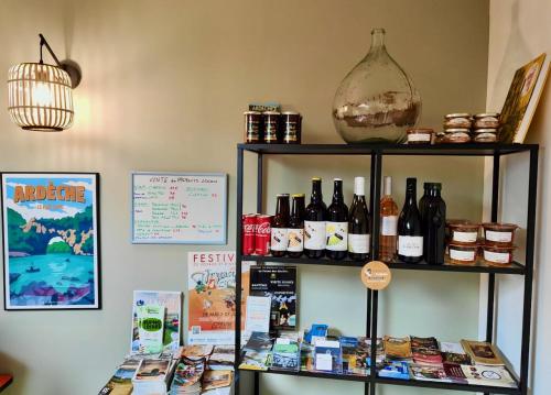 uma prateleira cheia de garrafas de vinho e livros em Camping du Vignal em Lablachère