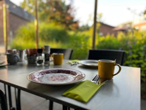 a table with a plate and a fork and a cup at Hostellerie Horst in Horst