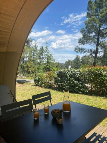 une table avec deux verres de jus posés dessus dans l'établissement Camping Hello Soleil, à Lablachère
