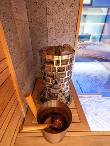 a pot on a wooden tray with a stack of logs at vitamaris Wellness Apartment & Spa in Muggia