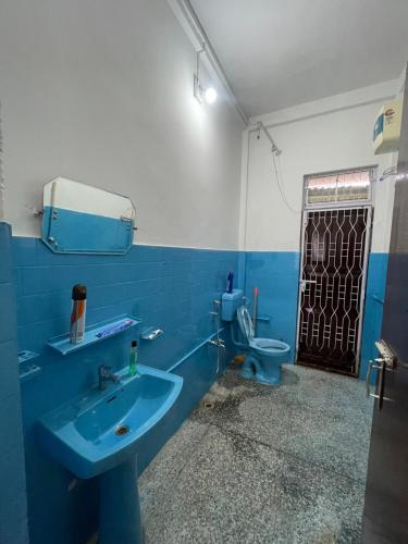 Un baño con un lavabo azul y un inodoro. en Notel Stays, en Jorhat