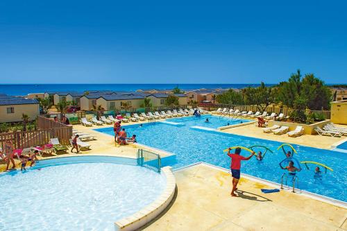 - une piscine dans un complexe avec des joueurs dans l'établissement LES PIEDS DANS L'EAU A PALAVAS ! Mer à 50 m ! MHome 6 Pers climatisé T confort CAMPING 4 ETOILES, à Palavas-les-Flots