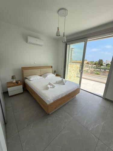 a bedroom with a bed and a large window at Theo luxury Napa villa in Ayia Napa