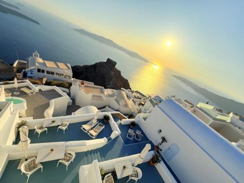 a group of white boats parked on the water at Sunset Caldera Seaview Houses in Imerovigli