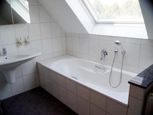 un baño con bañera y lavabo en La Domus Premium Osnabrück Lotte, en Lotte