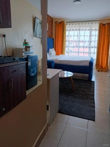 a room with a bedroom with a bed and a kitchen at Aheri Homes in Ruaka