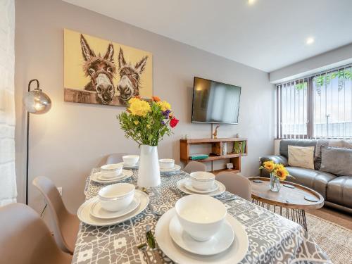 ein Wohnzimmer mit einem Tisch mit Stühlen und einer Couch in der Unterkunft The Granary - Uk41502 in Saint Twynnells