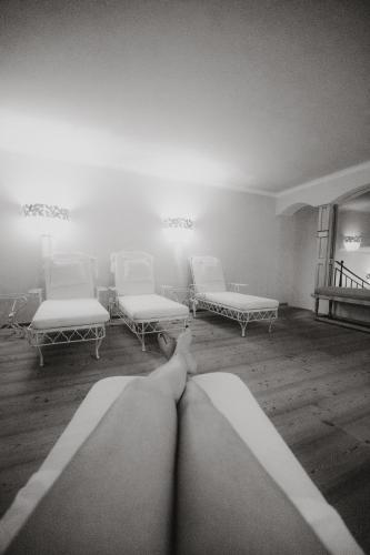 a room with two beds and two chairs at Hotel Alpenblick Zillertal in Hippach
