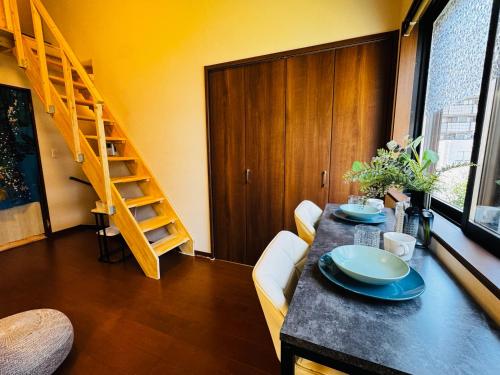 a dining room with a table and a staircase at Lucky you! YOTSUYA in Tokyo