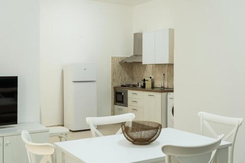 a kitchen with white cabinets and a table and chairs at Casa Vacanze Vanda in Ostuni