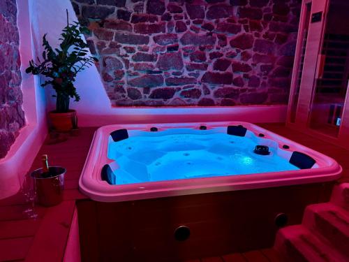 a hot tub in a room with a purple light at Exoria Luxury Rooms & SPA in Nuoro