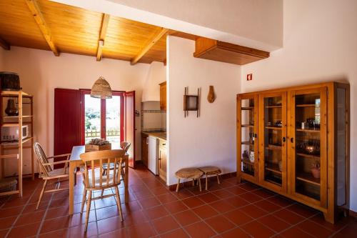una cucina e una sala da pranzo con tavolo e sedie di MONTE DA RAPOSINHA Enoturismo, Montargil a Montargil