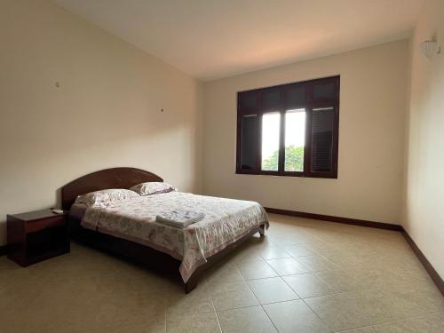 a bedroom with a bed and a window at Biệt Thự C19 Mũi Né Domaine in Ấp Chợ Dinh