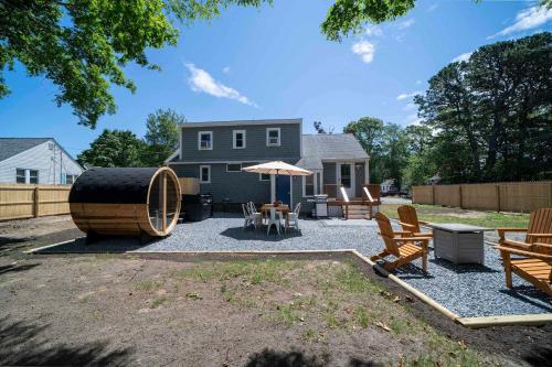 a backyard with a barrel and chairs and a table at Family Yarmouth Beach Resort 3BR Getaway in Yarmouth