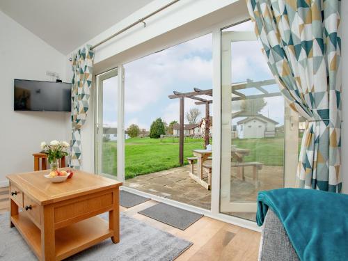 a living room with a sliding glass door to a patio at Wonkey Donkey Cottage in Seaton