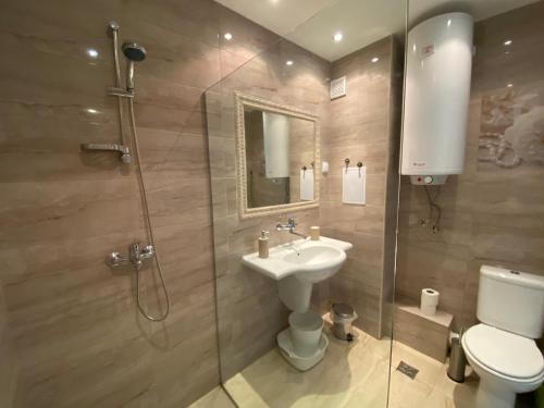 a bathroom with a shower and a sink and a toilet at Lilia Apartments Каваци, Созопол in Sozopol
