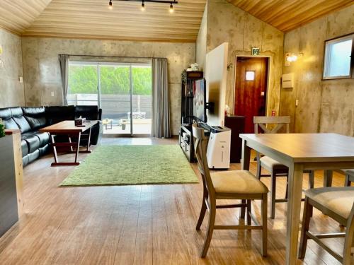 a living room with a couch and a table at 恩納村リゾート貸別荘 COCO PLUS No1 in Onna