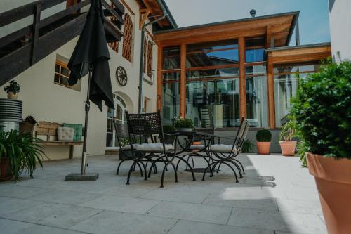 eine Terrasse mit Tisch und Stühlen und einem Sonnenschirm in der Unterkunft Bierhotel Loncium & Privatbrauerei in Kötschach