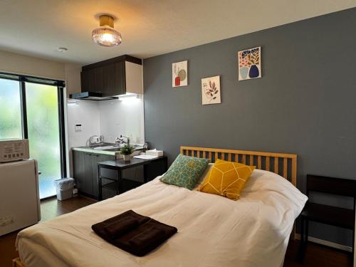 a bedroom with a large bed with yellow and green pillows at Lucky you! YOTSUYA in Tokyo