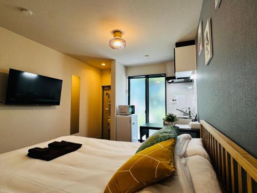 a bedroom with a bed and a flat screen tv at Lucky you! YOTSUYA in Tokyo