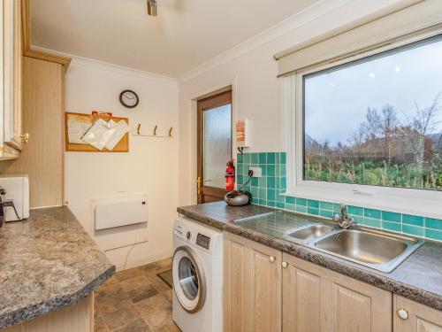 a kitchen with a sink and a window at Chesnut Cottage in Banavie