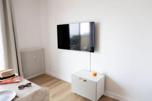 a white room with a tv on a wall at Studio vue mer clim plage aéroport Nice centre commercial centre affaires Nice Arenas emplacement excellent in Saint-Laurent-du-Var
