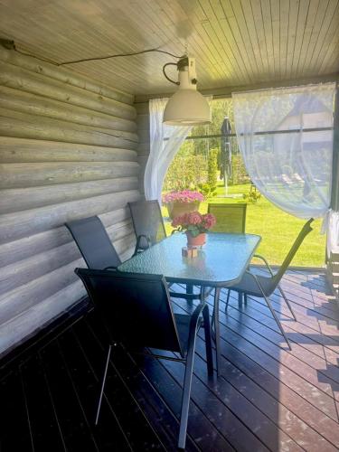 a table and chairs on a screened in porch at Brīdis Sev in Ķekava