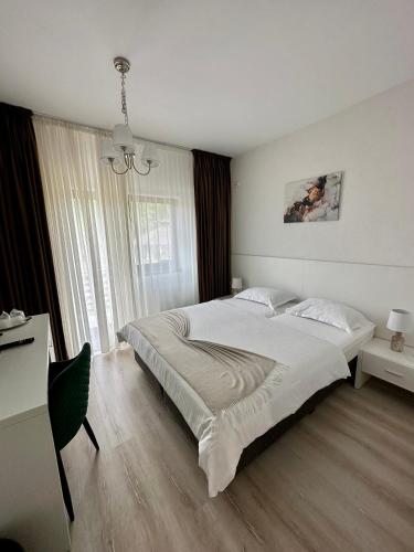 a bedroom with a large bed and a desk at Pensiunea Berg Hill in Băile Olăneşti