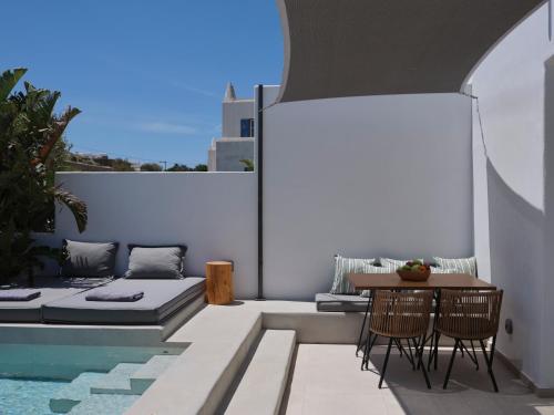 a balcony with a table and chairs and a couch at Le Palme Mykonos in Klouvas