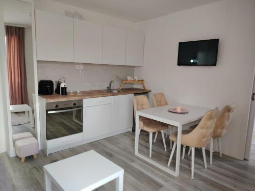 a kitchen with a table and a table and chairs at Eva Apartman in Prokuplje