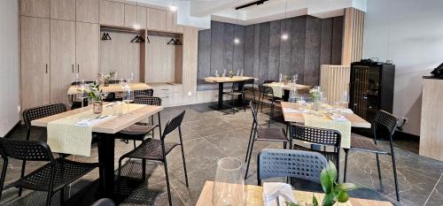 ein Restaurant mit Tischen und Stühlen in einem Raum in der Unterkunft HolidayHomePL Sea & Forest D344 z sypialnią, basen, spa, gym GRATIS in Misdroy