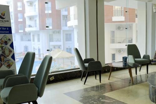 - une salle d'attente avec des chaises, une table et une fenêtre dans l'établissement One bedroom apartment in Aqua palm resort before Al Gouna, à Hurghada