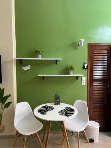 a table and chairs in a room with a green wall at Jenny's Apartments in Stratónion