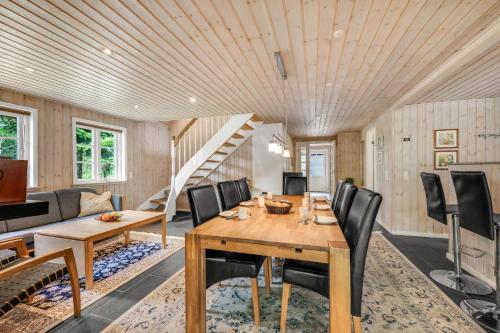 a dining room with a table and chairs and a staircase at Large Holiday Home With Large Outdoor Wilderness Bath And Activity Room, Only 500 Meters From Stauning Harbor in Skjern