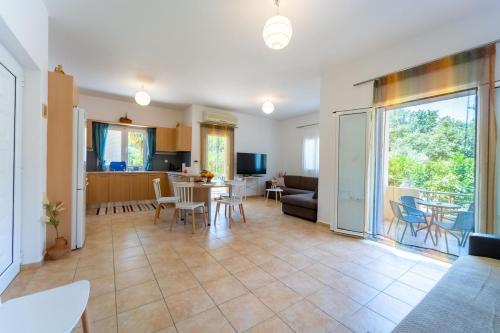 a living room with a table and chairs and a kitchen at Citrus Garden Home in Fodele in Fodele