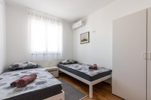 a bedroom with two beds and a window at Villa Orka in Omišalj