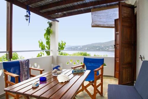a wooden table and chairs in a room with a view at Thalassia Studios in Kalamitsa